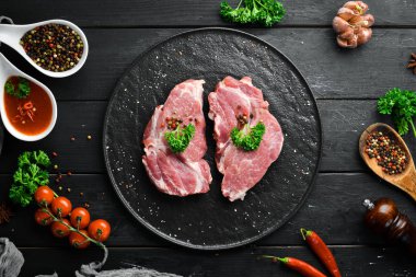 Çiğ domuz bifteği. Taze et. Bir tabak baharat ve ot. Üst te. Metniniz için boş alan.