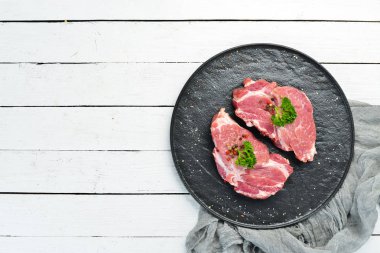 Çiğ domuz bifteği. Taze et. Bir tabak baharat ve ot. Üst te. Metniniz için boş alan.