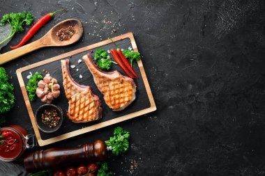 Baharat ve otlar ile kemik barbekü domuz biftek. Üst te. Metniniz için boş alan.