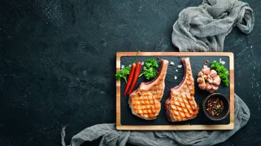 Baharat ve otlar ile kemik barbekü domuz biftek. Üst te. Metniniz için boş alan.