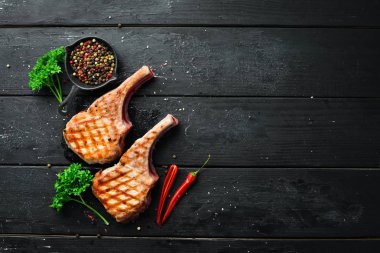 Baharat ve otlar ile kemik barbekü domuz biftek. Üst te. Metniniz için boş alan.