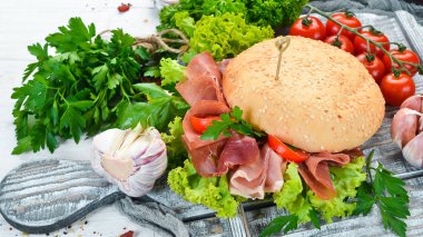 Eski ahşap arka plan prosciutto ile Burger. Kahvaltı. En iyi görünüm Metniniz için boş alan.