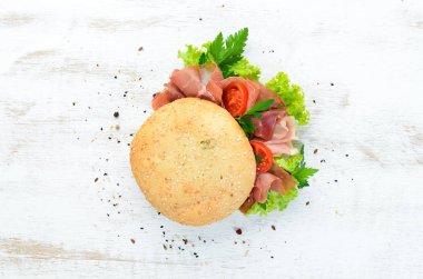 Eski ahşap arka plan prosciutto ile Burger. Kahvaltı. En iyi görünüm Metniniz için boş alan.