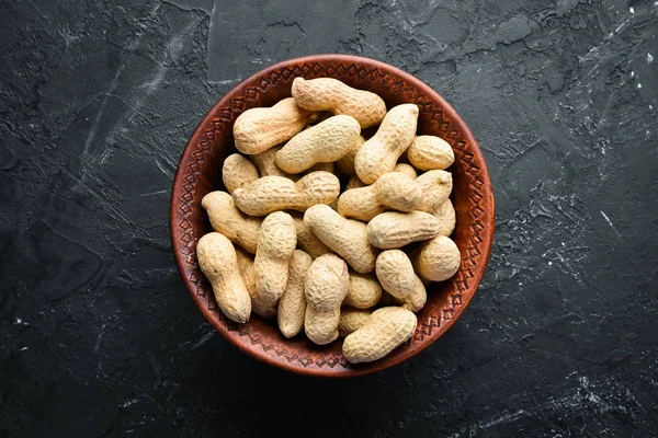 Peanuts on a black background. Nuts Top view. Free space for your text.