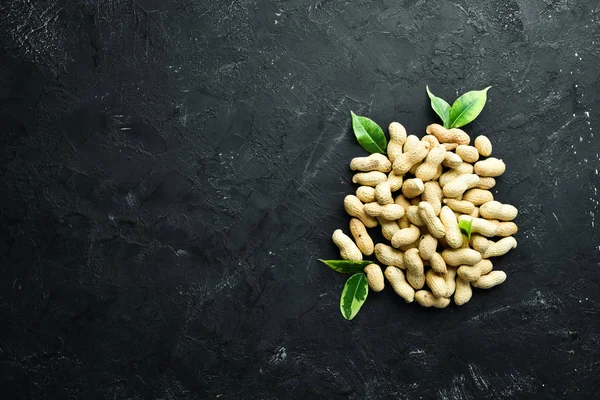 Peanuts on a black background. Nuts Top view. Free space for your text.