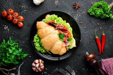 Eski ahşap arka plan prosciutto dilimleri ile Sandviç. Kruvasan Kahvaltı. Üst te. Metniniz için boş alan.