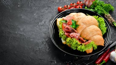 Eski ahşap arka plan prosciutto dilimleri ile Sandviç. Kruvasan Kahvaltı. Üst te. Metniniz için boş alan.