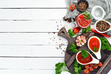 Ketçap, barbekü sosu, domates sosu. Beyaz ahşap arka plan üzerinde domates sosları bir dizi. Üst te. Metniniz için boş alan.