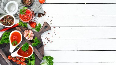 Ketçap, barbekü sosu, domates sosu. Beyaz ahşap arka plan üzerinde domates sosları bir dizi. Üst te. Metniniz için boş alan.