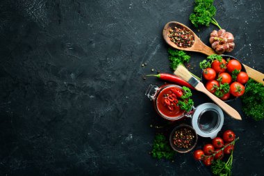 Siyah taş arka plan üzerinde domates sosları bir dizi. Ketçap, barbekü sosu, domates sosu. Üst te. Metniniz için boş alan.