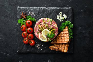 Çiğ yumurta sarısı, avokado, kapari ve soğan ile Sığır biftek tartar. Fransız mutfağı. Üst te. Metniniz için boş alan.