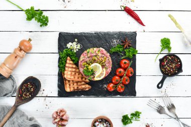 Çiğ yumurta sarısı, avokado, kapari ve soğan ile Sığır biftek tartar. Fransız mutfağı. Üst te. Metniniz için boş alan.