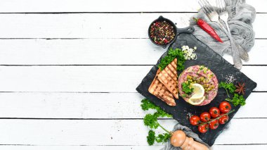 Çiğ yumurta sarısı, avokado, kapari ve soğan ile Sığır biftek tartar. Fransız mutfağı. Üst te. Metniniz için boş alan.