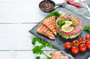 Çiğ yumurta sarısı, avokado, kapari ve soğan ile Sığır biftek tartar. Fransız mutfağı. Üst te. Metniniz için boş alan.