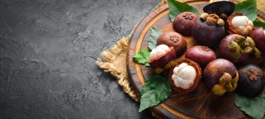 Tropikal meyveler, ahşap bir arka plan üzerinde Mangosteen. Üst te. Metin için boş alan.