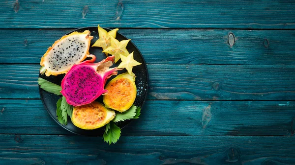 Tropical Fruits - Cactus and dragon fruit on a wooden background. Top view. Free space for text.