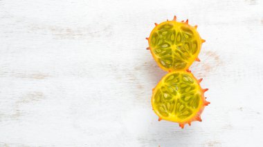 Kiwano beyaz ahşap bir arka plan üzerinde. Tropikal Meyveler. Üst te. Metin için boş alan.