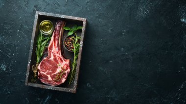 Siyah bir arka plan üzerinde çiğ kuru biftek tomahawk. Biftek Kovboyu. Barbekü. Üst te. Metin için boş alan.