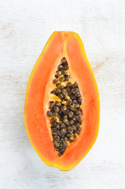 Beyaz ahşap arka plan üzerinde tatlı olgun taze papaya. Üst te. Metin için boş alan.