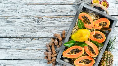 Beyaz ahşap arka plan üzerinde tatlı olgun taze papaya. Üst te. Metin için boş alan.