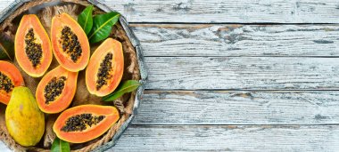 Beyaz ahşap arka plan üzerinde tatlı olgun taze papaya. Üst te. Metin için boş alan.