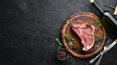 Siyah taş masada çiğ t-kemik biftek. Üst te. Metin için boş alan.