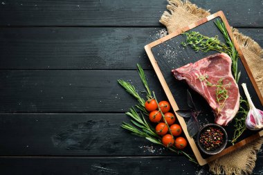 Tahta bir masada çiğ t-kemik biftek. Üst te. Metin için boş alan.
