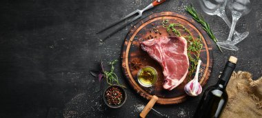 Tahta bir masada çiğ t-kemik biftek. Üst te. Metin için boş alan.