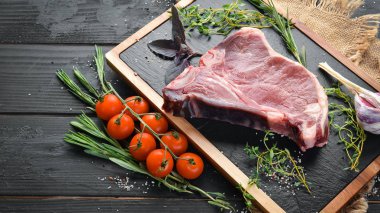 Tahta bir masada çiğ t-kemik biftek. Üst te. Metin için boş alan.