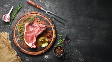 Tahta bir masada çiğ t-kemik biftek. Üst te. Metin için boş alan.