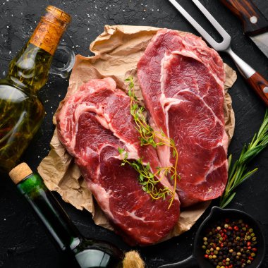 Çiğ Biftek Ribeye. Siyah taş bir masanın üzerinde. Üst te. Metniniz için boş alan.