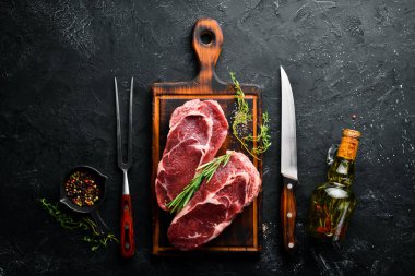 Çiğ Biftek Ribeye. Siyah taş bir masanın üzerinde. Üst te. Metniniz için boş alan.