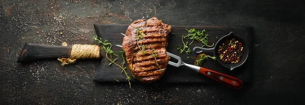 Izgara Ribeye Sığır Eti Biftek Otlar Baharatlar Karanlık Bir Masada — Stok fotoğraf