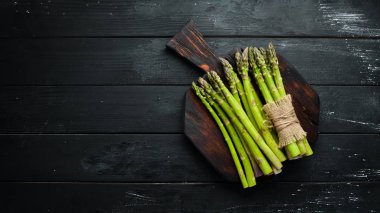 Yeşil kuşkonmaz. Siyah bir arka plan üzerinde taze kuşkonmaz. Üst te. Metniniz için boş alan.