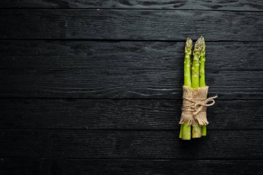 Yeşil kuşkonmaz. Siyah bir arka plan üzerinde taze kuşkonmaz. Üst te. Metniniz için boş alan.