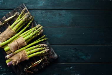 Yeşil kuşkonmaz. Siyah bir arka plan üzerinde taze kuşkonmaz. Üst te. Metniniz için boş alan.