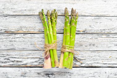 Beyaz ahşap arka plan üzerinde taze yeşil kuşkonmaz. Sağlıklı yiyecekler. Üst te. Metniniz için boş alan.