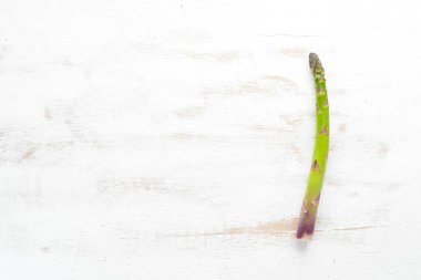 Beyaz ahşap arka plan üzerinde taze yeşil kuşkonmaz. Sağlıklı yiyecekler. Üst te. Metniniz için boş alan.