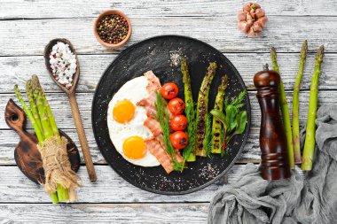 Kahvaltı. Kuşkonmaz, yumurta, pastırma ve kiraz domates. Sağlıklı yiyecekler. Üst te. Metniniz için boş alan.