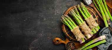 Kahverengi arka planda kuşkonmaz. Yeşil kuşkonmaz. Üst te. Metniniz için boş alan.