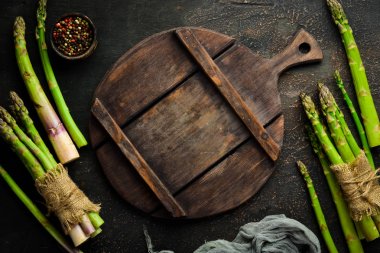 Kahverengi arka planda kuşkonmaz. Yeşil kuşkonmaz. Üst te. Metniniz için boş alan.