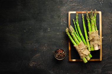 Kahverengi arka planda kuşkonmaz. Yeşil kuşkonmaz. Üst te. Metniniz için boş alan.