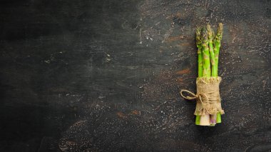 Kahverengi arka planda kuşkonmaz. Yeşil kuşkonmaz. Üst te. Metniniz için boş alan.