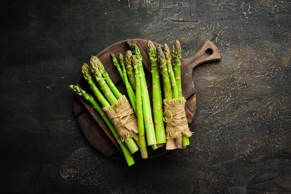 Asparagus on a brown background. Green asparagus. Top view. Free space for your text.