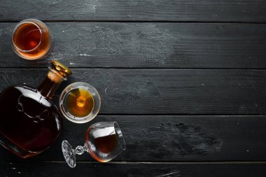 Siyah bir arka plan üzerinde bir bardak brendi. Üst te. Metniniz için boş alan.