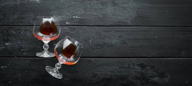 Siyah bir arka plan üzerinde bir bardak brendi. Üst te. Metniniz için boş alan.