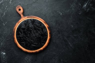 Siyah bir arka plan üzerinde eski Ahşap mutfak tahtası. Üst te. Metniniz için boş alan.