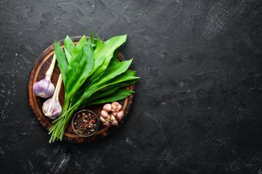 Siyah arka planda taze yabani sarımsak yaprakları. Yabani pırasa. Üst te. Metniniz için boş alan.