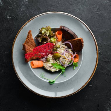 Ringa balığı tartar bir tabakta. Rustik tarz. Üst te. Metniniz için boş alan.