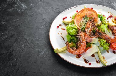 Karides ve avokado ile salata. Tabakta. Rustik tarz. Üst te. Metniniz için boş alan.